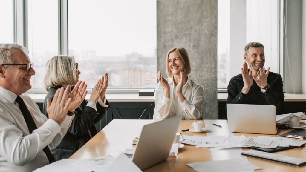 Business professionals clapping in a conference room, creating a lively and positive work environment.