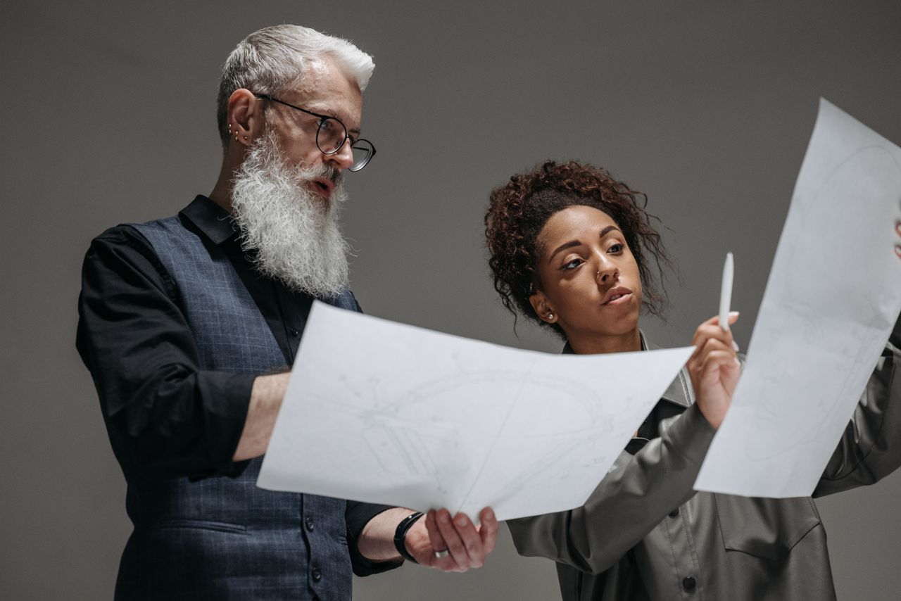 Two colleagues engaged in a design discussion, analyzing architectural plans.